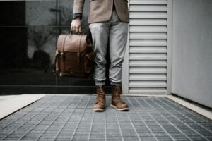 person holding brown leather bag, best travel dresses