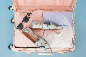 clothing items and pair of shoes in luggage, Fold travel dress, travel dress, fold a dress for travel